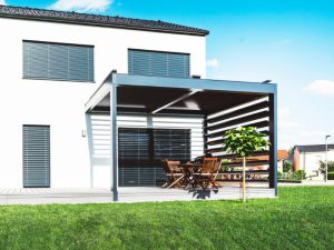 Modern home exterior with festoon lights on pergola and wooden patio set in the backyard.