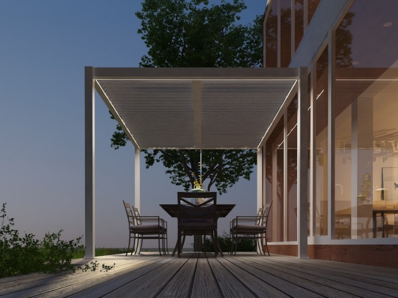 Front view of illuminated louvered pergola over patio dining table, showing options before staining pergola surfaces.