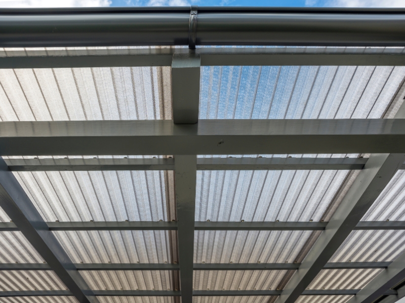 Transparent pergola roof with metal framing, demonstrating structural elements that may lead to a leaking pergola roof.