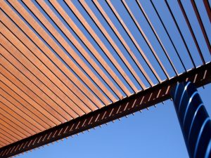 Close-up of wooden slats in a pergola design, showcasing gaps that could contribute to a leaking pergola roof.