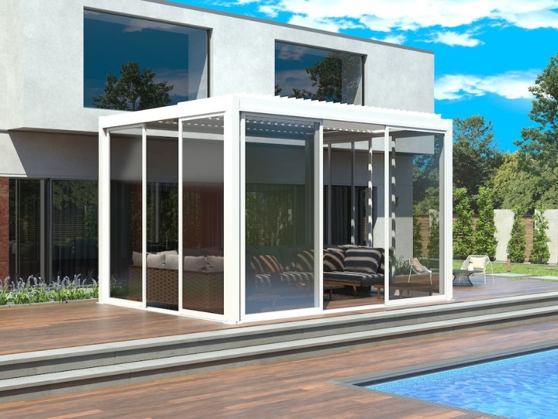 Enclosed Front Patio Pergola with glass walls beside pool and modern home.