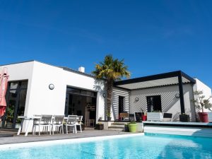 Modern poolside pergola with adjustable louvres, creating shade and a stylish outdoor space.