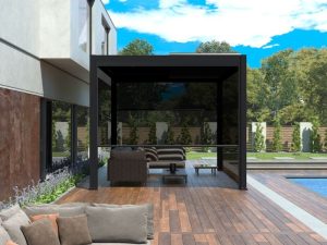 Modern black pergola post with glass panels providing shade on a stylish patio beside a swimming pool.