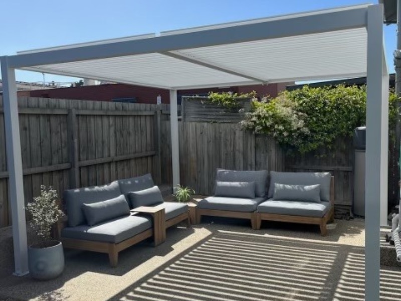 Open Pergola with white frame shading outdoor seating in a private backyard.