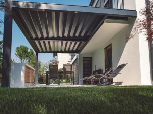 Enhance outdoor space pergola with a sleek black louvered roof, cosy seating, and a built-in outdoor dining area.