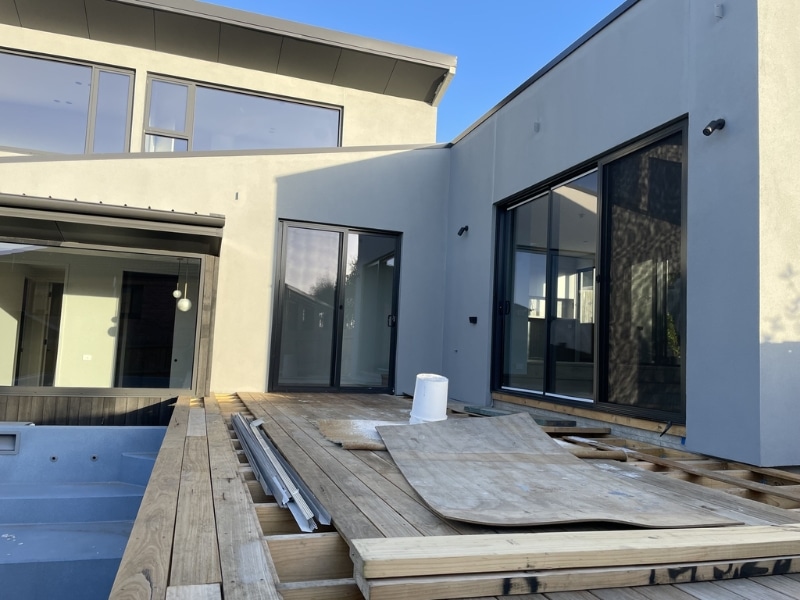 Sagging Pergola prevention shown with new deck construction beside modern home before pergola installation.