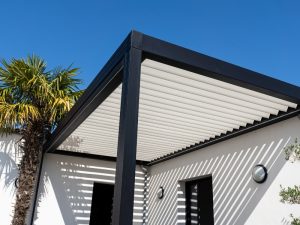 Modern black pergola with adjustable louvers showing early signs of a sagging pergola due to structural issues.