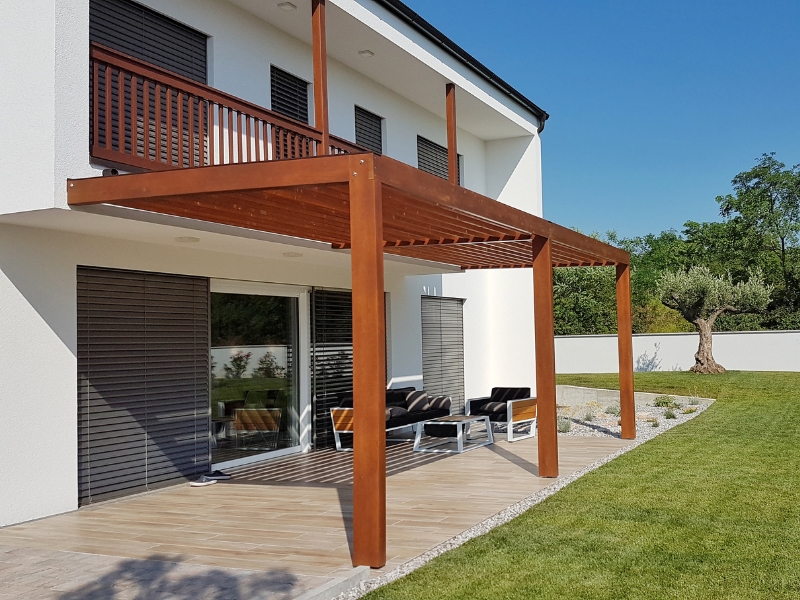 Wooden pergola attached to a house, illustrating potential sagging pergola risks if not properly maintained.