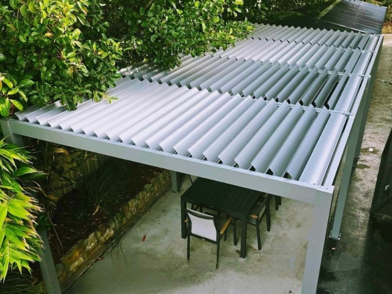 Motorised Pergola Pet Safety shown with adjustable louvre roof over small outdoor seating space.