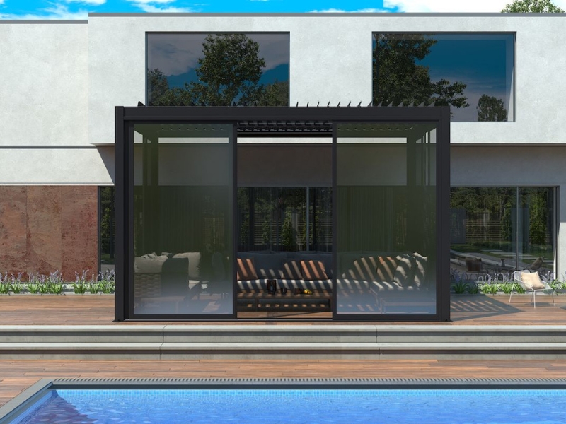 Modern budget pergola enhancements featuring a sleek black aluminium frame with retractable glass panels, poolside seating, and stylish shade.