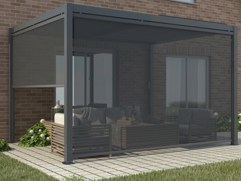 Pergola in winter with protective screens enclosing outdoor lounge area at brick home.