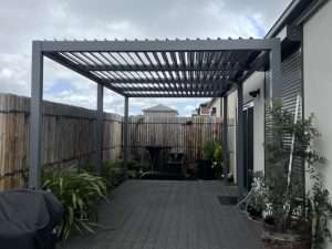 Modern corner pergola with sides in narrow backyard, ideal for privacy and stylish outdoor use.