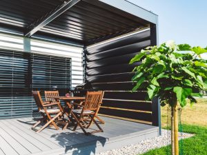 Corner pergola with sides featuring wooden deck and adjustable privacy panels for flexible shading.