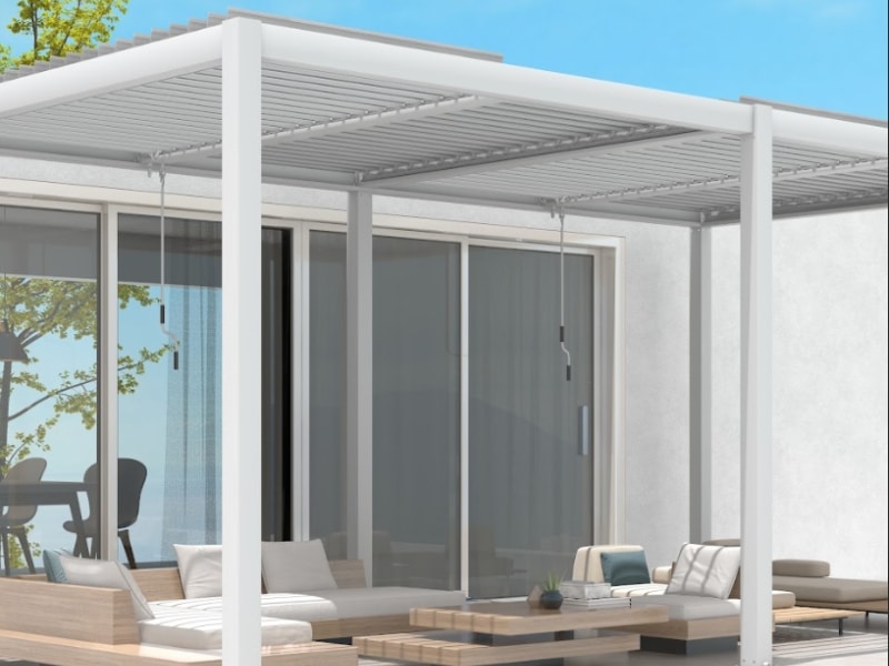 Basic Pergola Designs showing a white pergola structure covering outdoor seating beside large sliding glass doors.