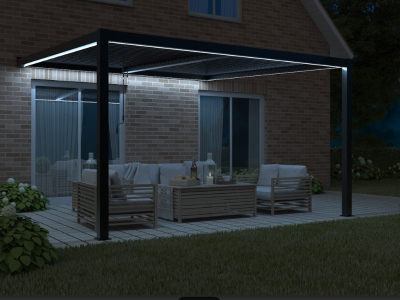 Pergola With Adjustable Roof featuring LED lighting above outdoor seating beside a brick house at night.
