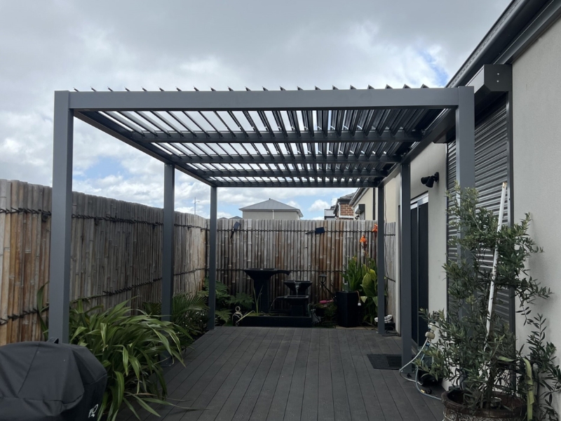 Modern grey wall pergola kits installed on narrow deck beside house.