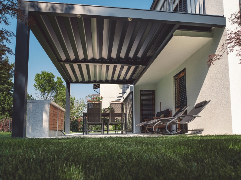 Modern backyard dining area shaded by portable pergola kits with adjustable louvre roof and sleek metal frame