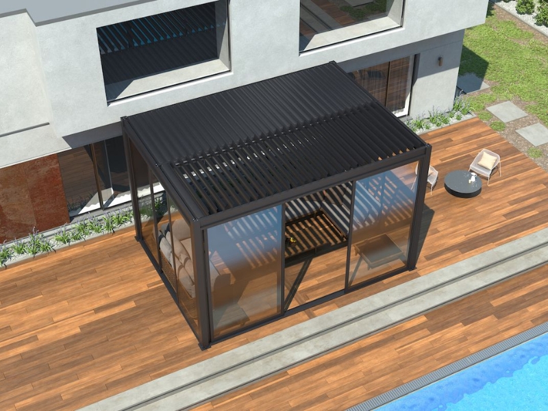 Modern fully enclosed pergola with black louvred roof and glass walls beside pool on timber deck