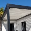 Portable pergola kits with white aluminium louvres creating dynamic shadows on a rendered home exterior