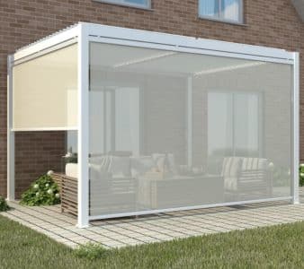 White motorised louvered pergola with clear retractable screens, attached to brick home for stylish weather-protected outdoor living.