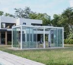 Modern glass enclosure in backyard with lounge seating, a stylish and functional outdoor living add on for contemporary homes.