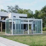 Modern glass enclosure in backyard with lounge seating, a stylish and functional outdoor living add on for contemporary homes.
