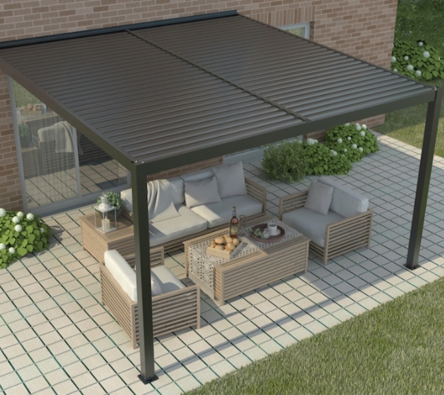 Wall mounted manual louvered pergola in black, attached to brick home with outdoor lounge setting on paved patio.