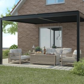 Modern wall-mounted manual louvered pergola with sleek black frame over a cozy outdoor lounge area featuring light wooden furniture and a brick house backdrop.