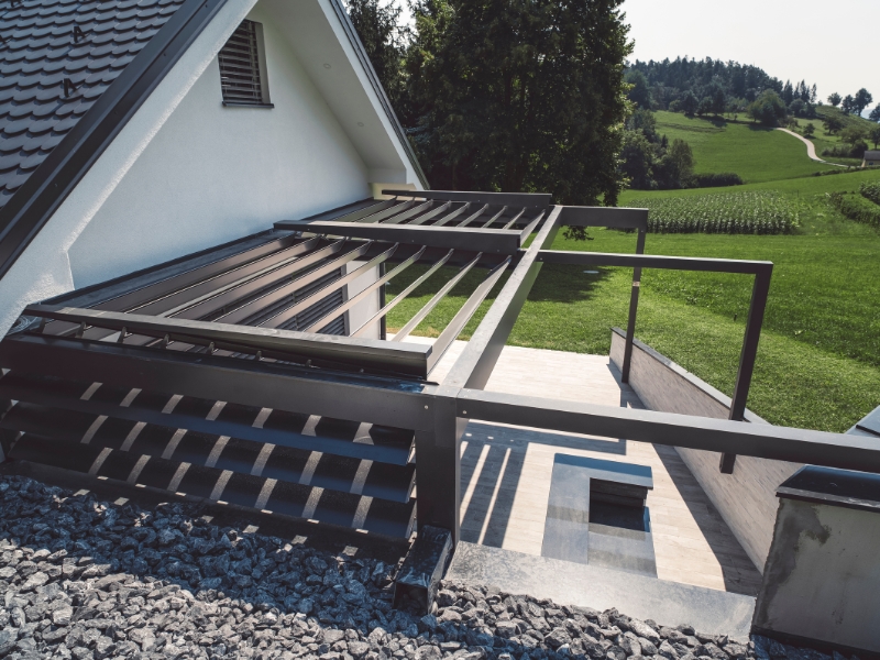 Modern garage pergola designs with metal frame overlooking green landscape.