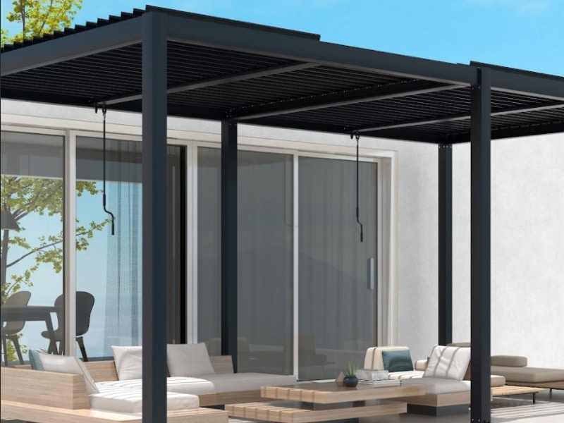Pergola installation cost shown with black framed louvre pergola attached to house over lounge seating.