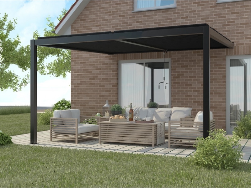 Pergola on side of house with modern outdoor seating and timber furniture under black louvre roof.