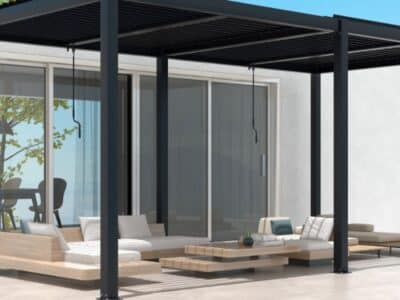 Modern pergola structure built over a smooth pergola concrete slab with outdoor lounges and sliding glass doors.