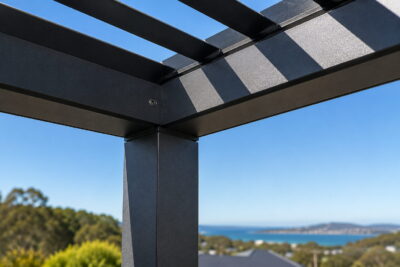 Close-up of a charcoal powder-coated aluminium louvred pergola corner against a clear sky